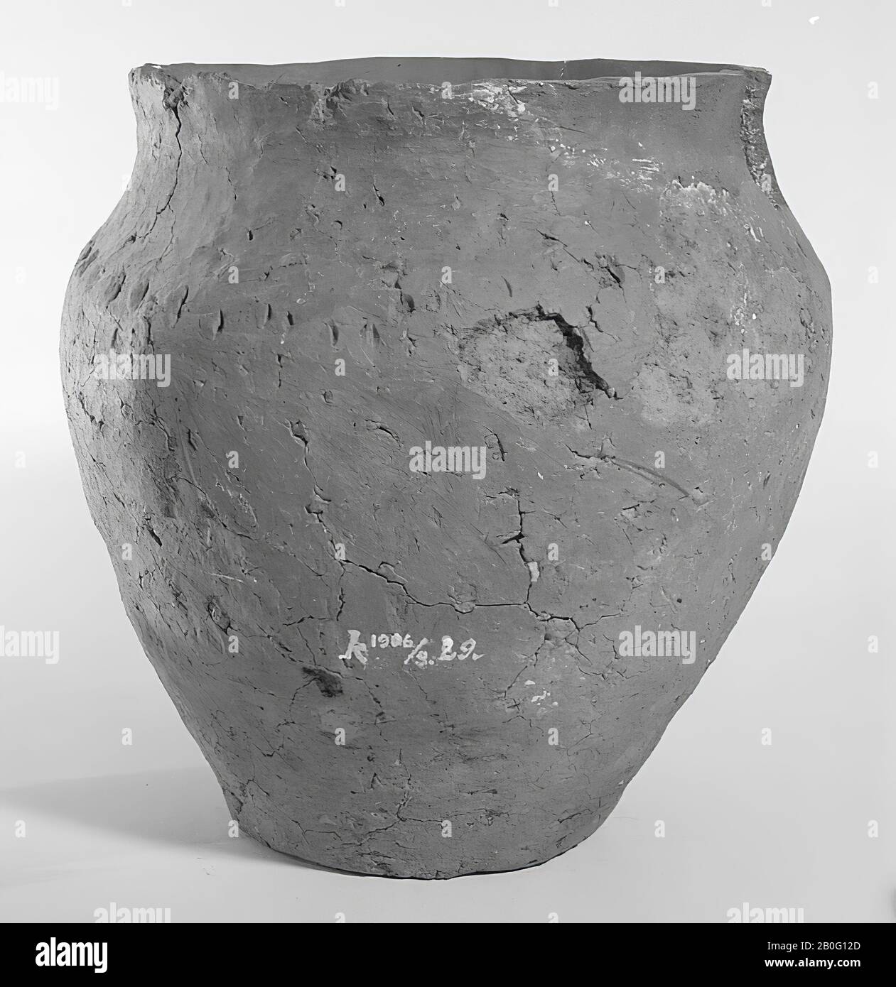 Urn of reddish-brown baked earth. The belly is raised high and decorated with nail artifacts from above over the entire circumference. Additions, open cracks in the edge, splitting cracks, surface damage, 2 loose fragments from the gap in the edge Stock Photo