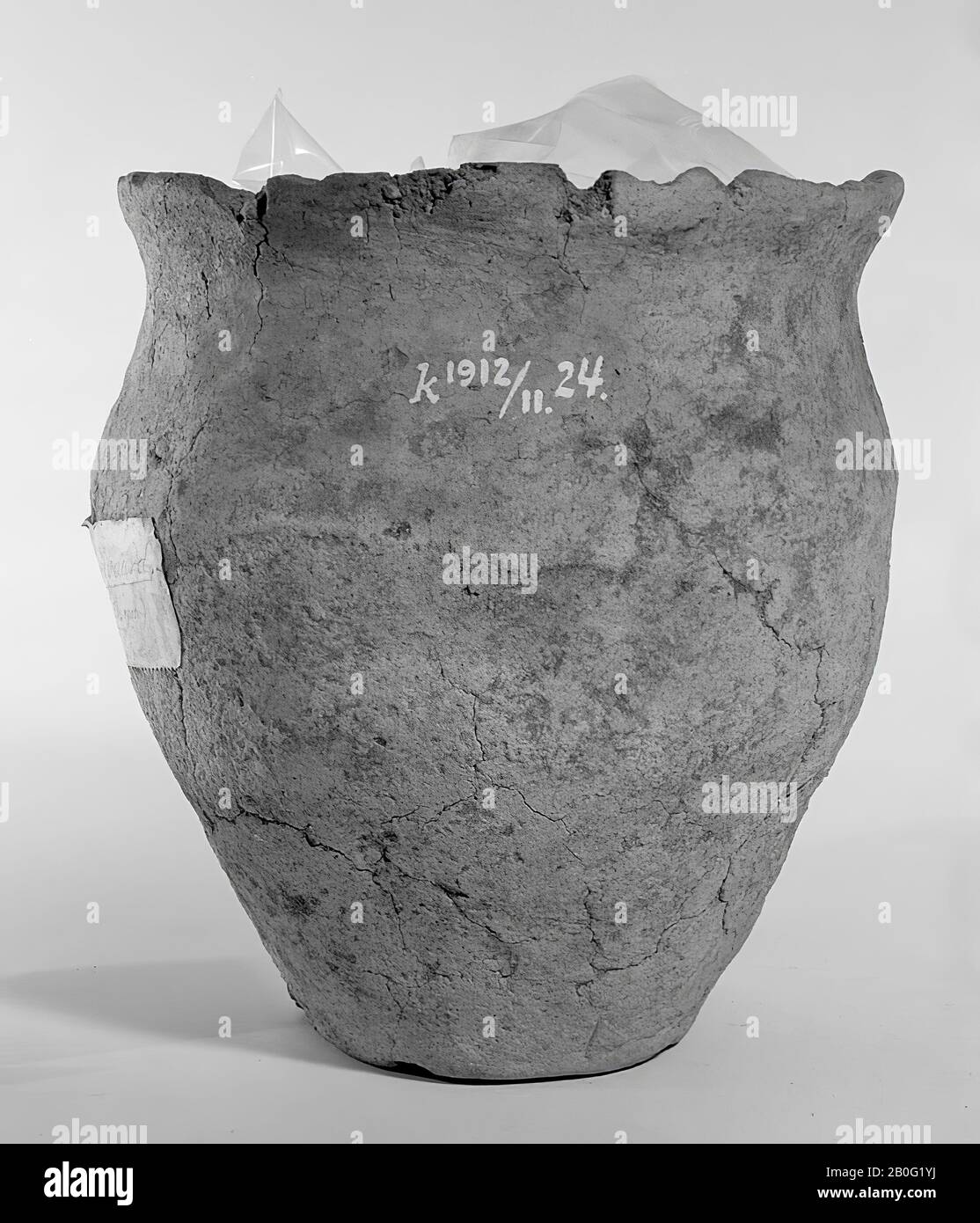 Germanic urn of earthenware. Part of the edge is missing, network of cracks, 4 loose shards. Contains cremated residues, urn, earthenware, h: 17,5 cm, diam: 17,5 cm, prehistory -1200 Stock Photo