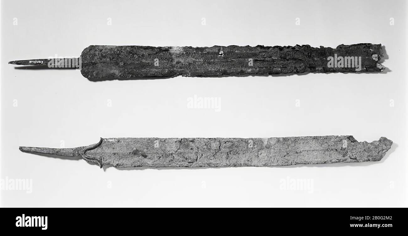 large fragment of an iron swordkit with narrow tongue and odd cuts. The transition between blade and tongue and the angle of the blade around it. The blade shows longitudinal conduction, because two broad depressions have been applied next to the middle rib by hammering (small dents). This is the case on both sides of the blade. The blade is broken off across and the tip is missing, sword, metal, iron, length: 57.3 cm, prehistory -500 Stock Photo