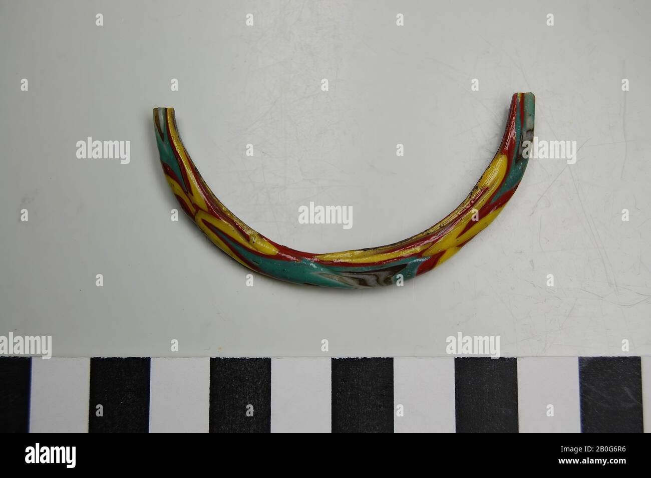 Fragment of glass bracelet with decoration in red, yellow and green. Old inventory number: 12287., bracelet, fragment, glass, 6 cm, Roman 50-100, Egypt Stock Photo