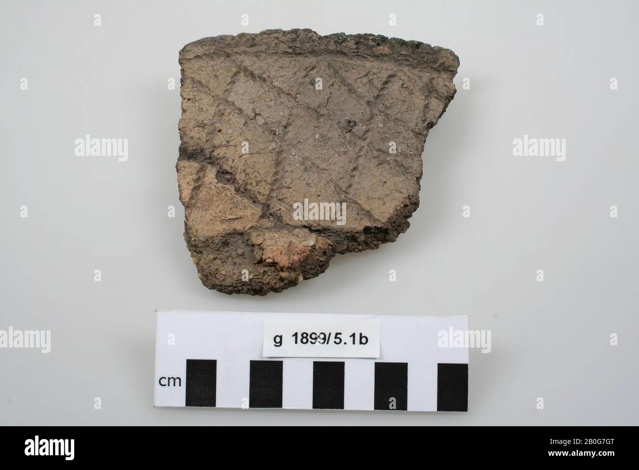 Border fragment of a cinerary urn. The edge is vertical, decorated with a diamond pattern of rope prints. SUPERSONIC Material strongly agitated with quartz grit. 1 bonding, shard, earthenware, 10 x 11 x 2.7 cm, prehistory -1800 Stock Photo