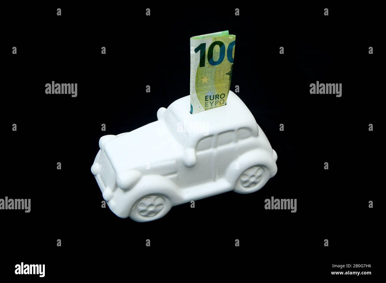 The ceramic car shaped money box with a banknote inside. It can be symbol for costs for car´s repairs, investment, savings or insurance. Stock Photo