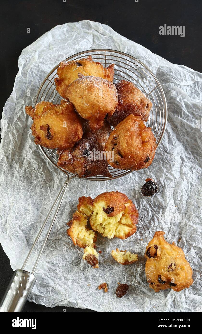 Concept of italian food. Top view of homemade traditional carnival sweets: carnival italian fritters with sultanas on dark background. Stock Photo