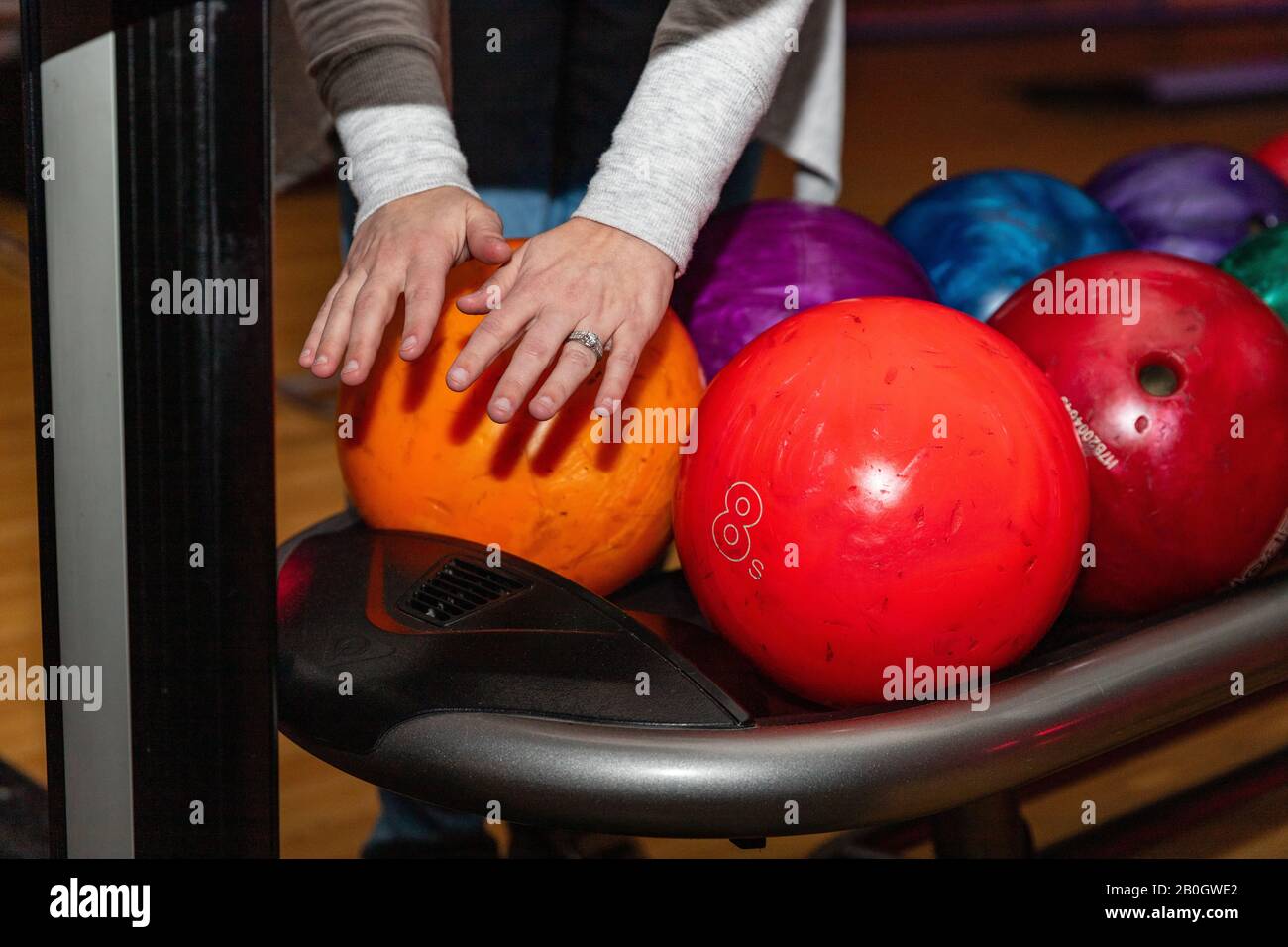 Bowler drying hands in front of bowling balls Stock Photo