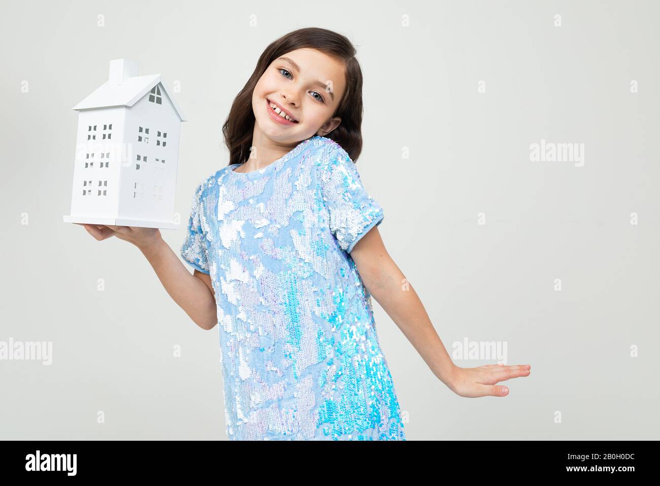 smiling teenager girl with a mock up at home on a white background with copy space. immovable property Stock Photo