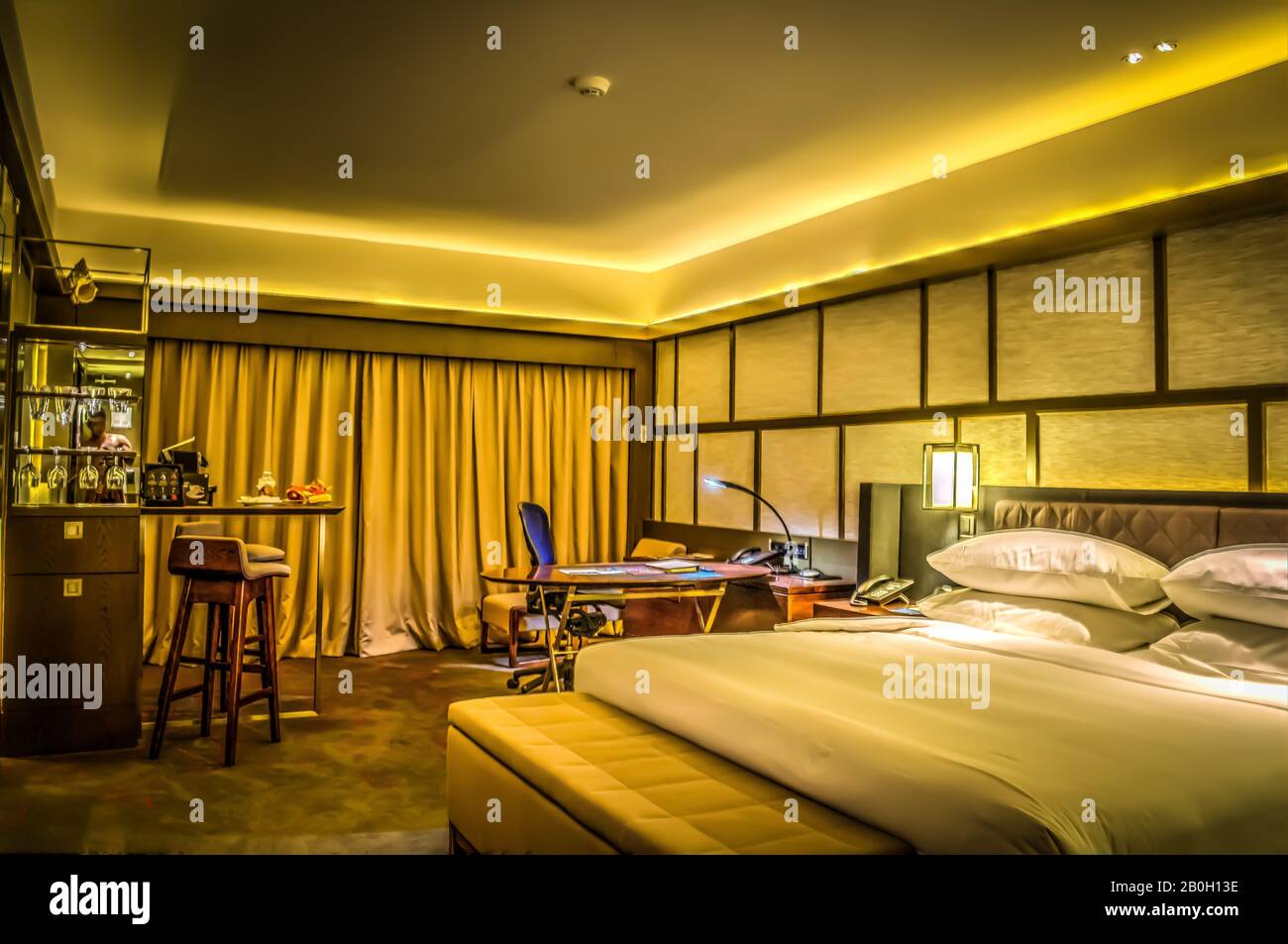 beautiful interior of bedroom with bed, office desk and lamp and