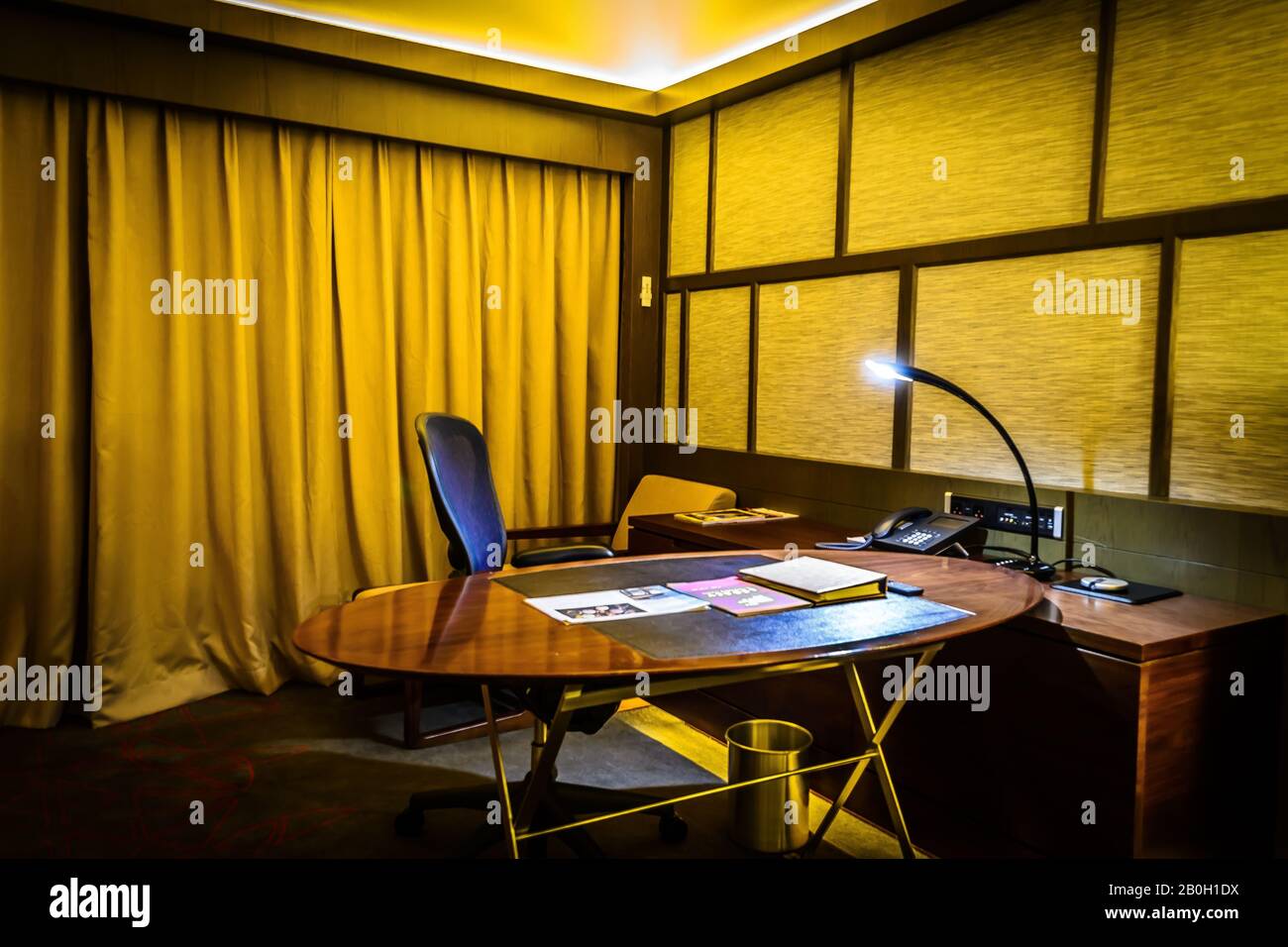 beautiful interior of bedroom with bed, office desk and lamp and