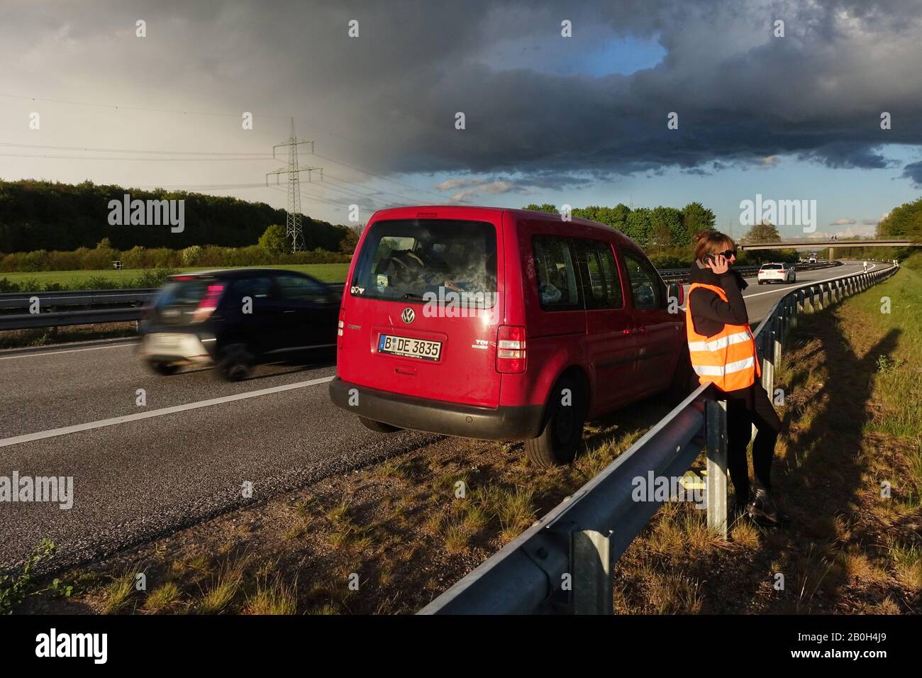04.05.2019, Hamburg, Hamburg, Germany - Woman stands behind the crash barrier in a car breakdown on the A24 and makes a phone call. 00S190504D669CAROE Stock Photo