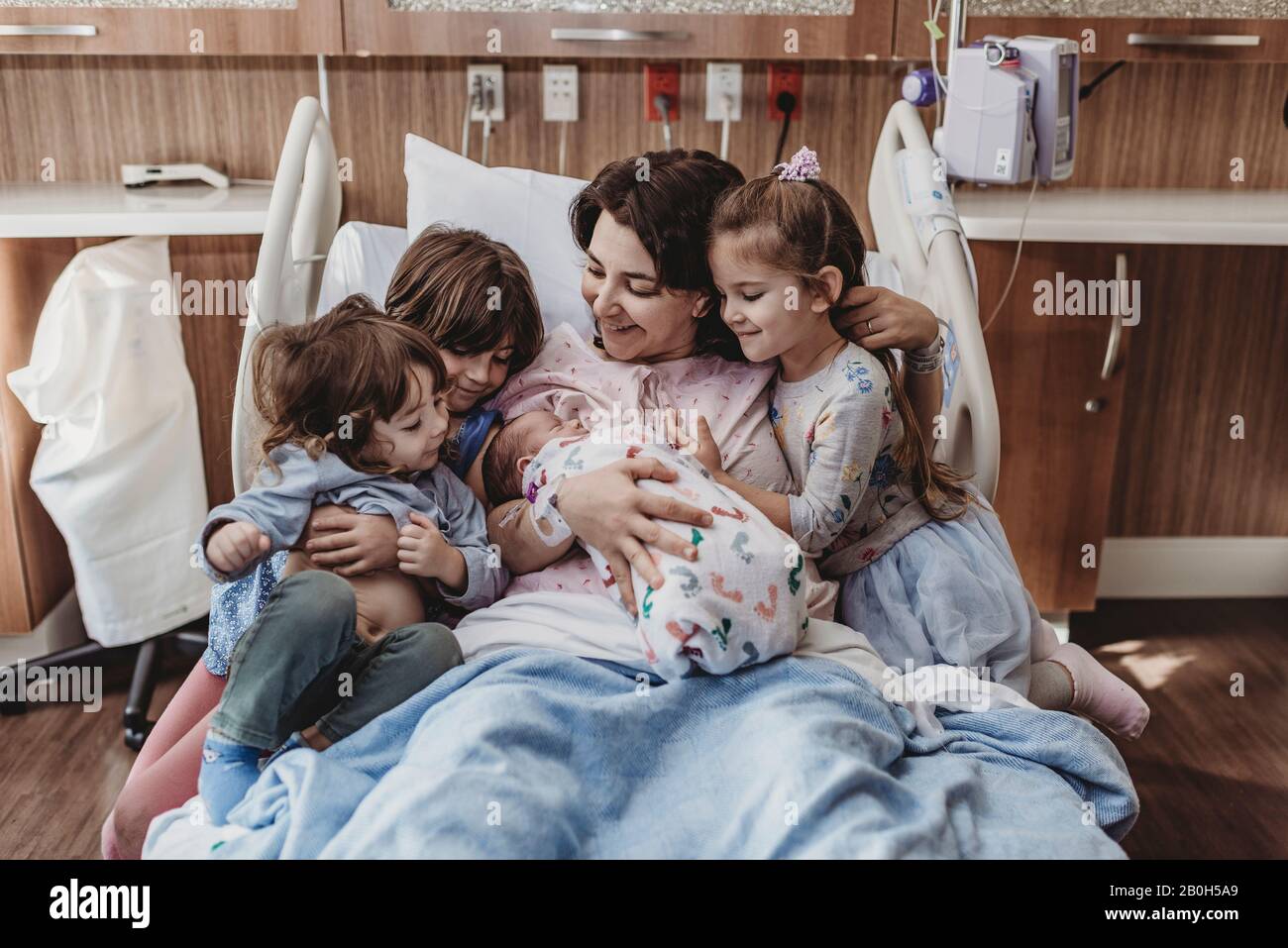 Mid view of mom and children holding newborn son Stock Photo