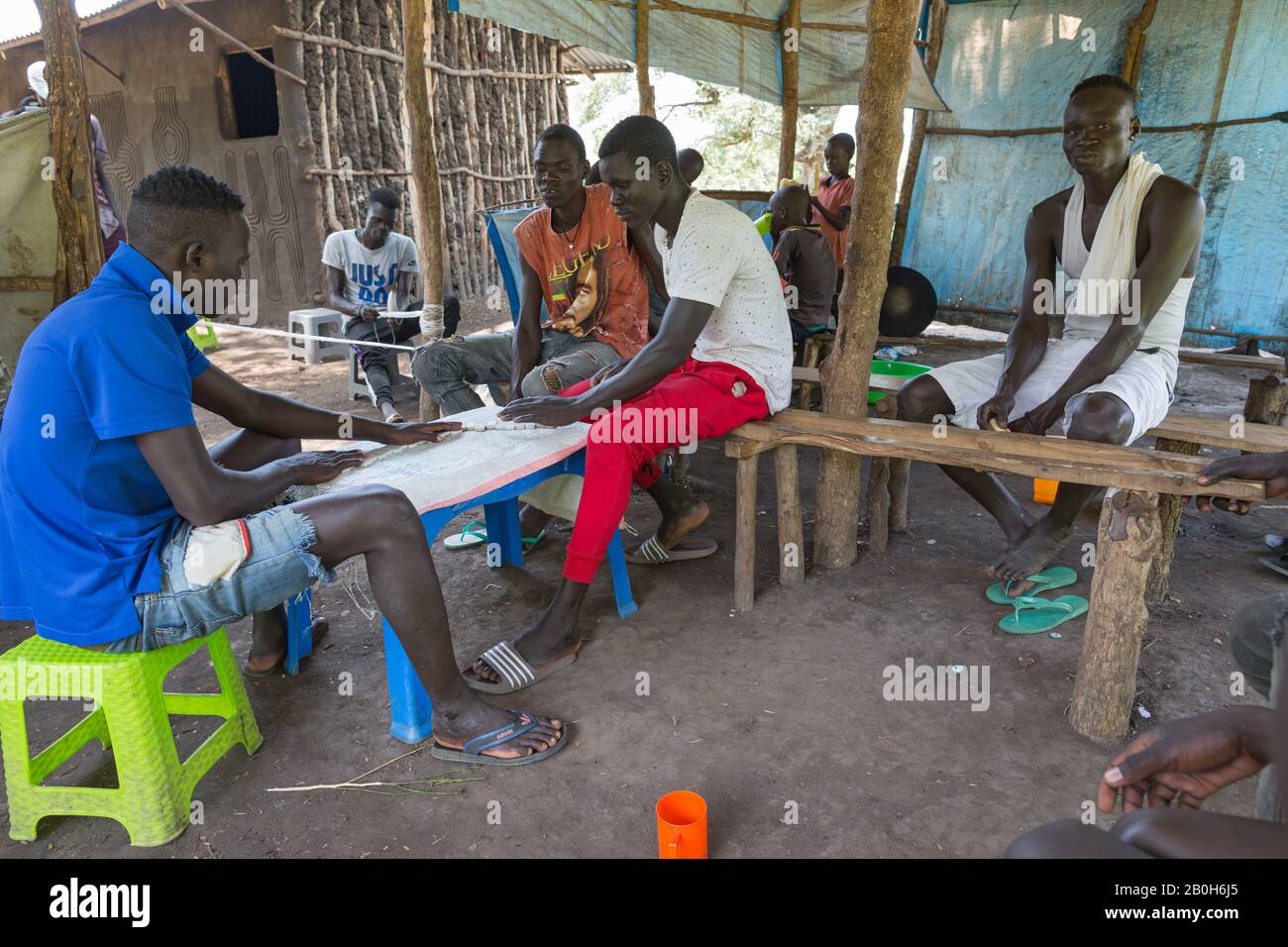 30.10.2019, Opanya, Gambela, Ethiopia - Young men play dominoes in a dwelling covered with plastic film. Project documentation of the Ev.-luth. missio Stock Photo