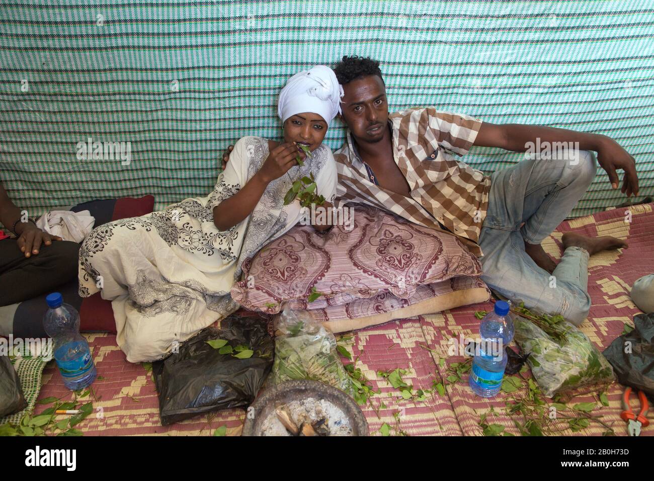 02.11.2019, Adama, Oromiyaa, Ethiopia - A woman and a man sit on the floor chewing khat. The woman holds a khat branch. 8000 IDPs from the Somalia reg Stock Photo