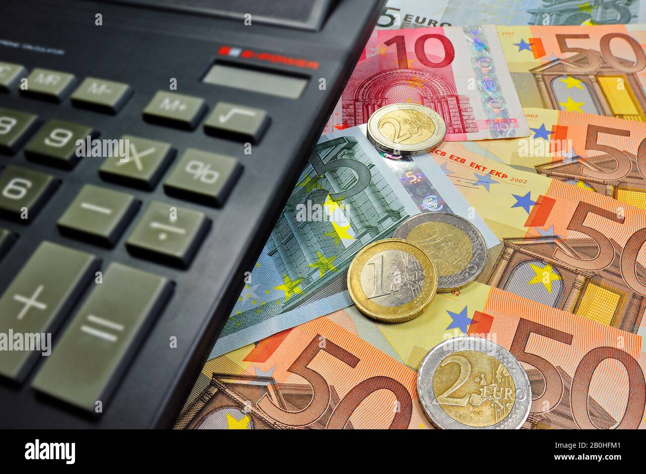 Euro banknotes and coins and pocket calculator Stock Photo