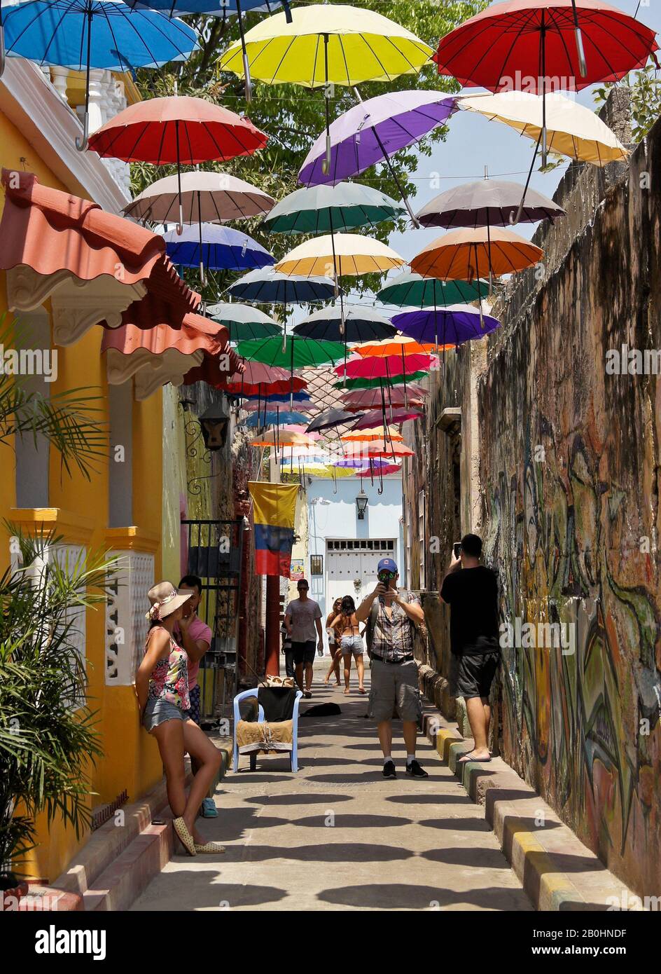 Street art and overhead umbrellas provide color and shade on Callejon
