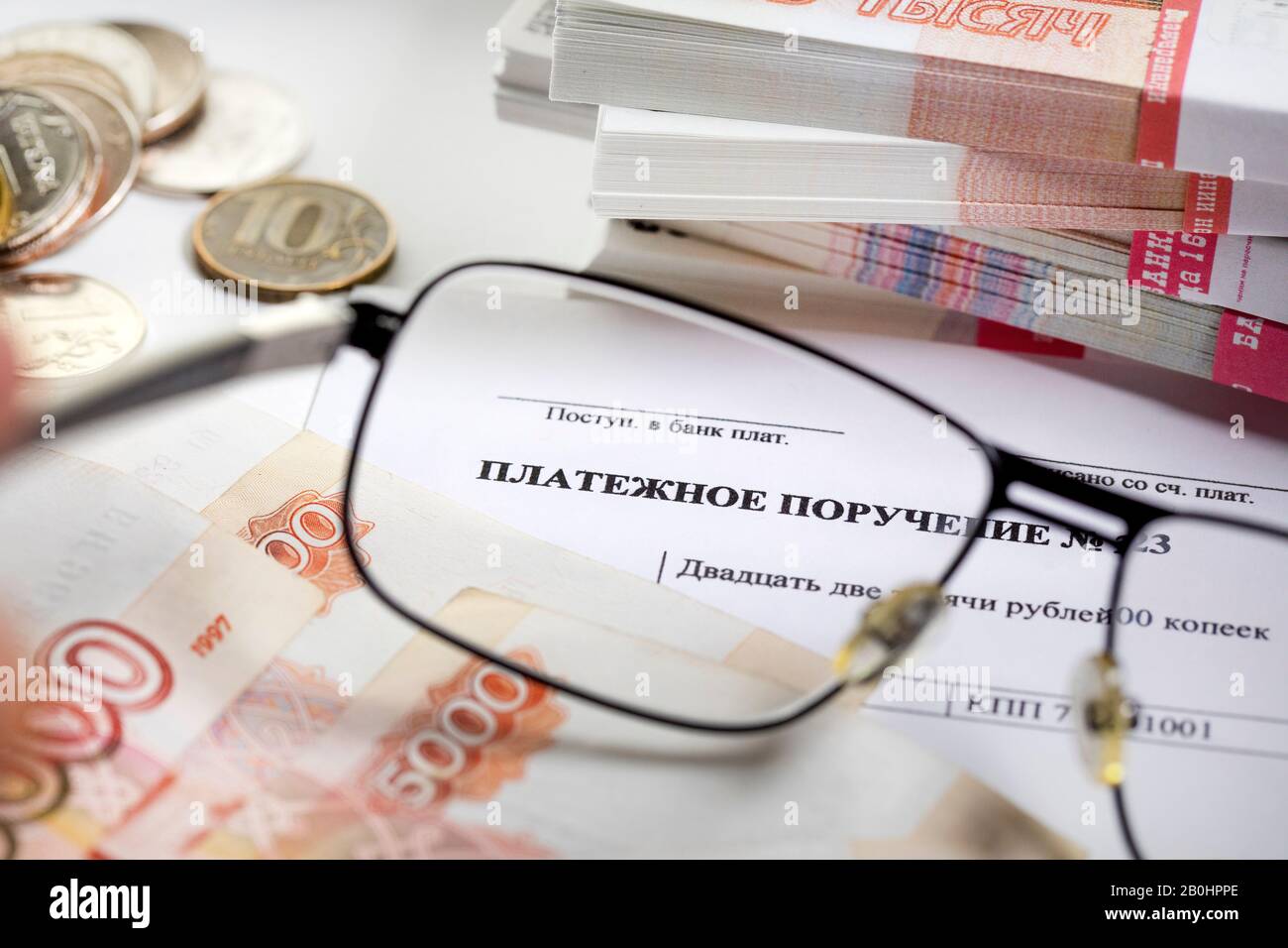 Russian form of a payment order to a bank is on an accountant's desk with Russian banknotes. Russian inscription reads "A payment order" Stock Photo