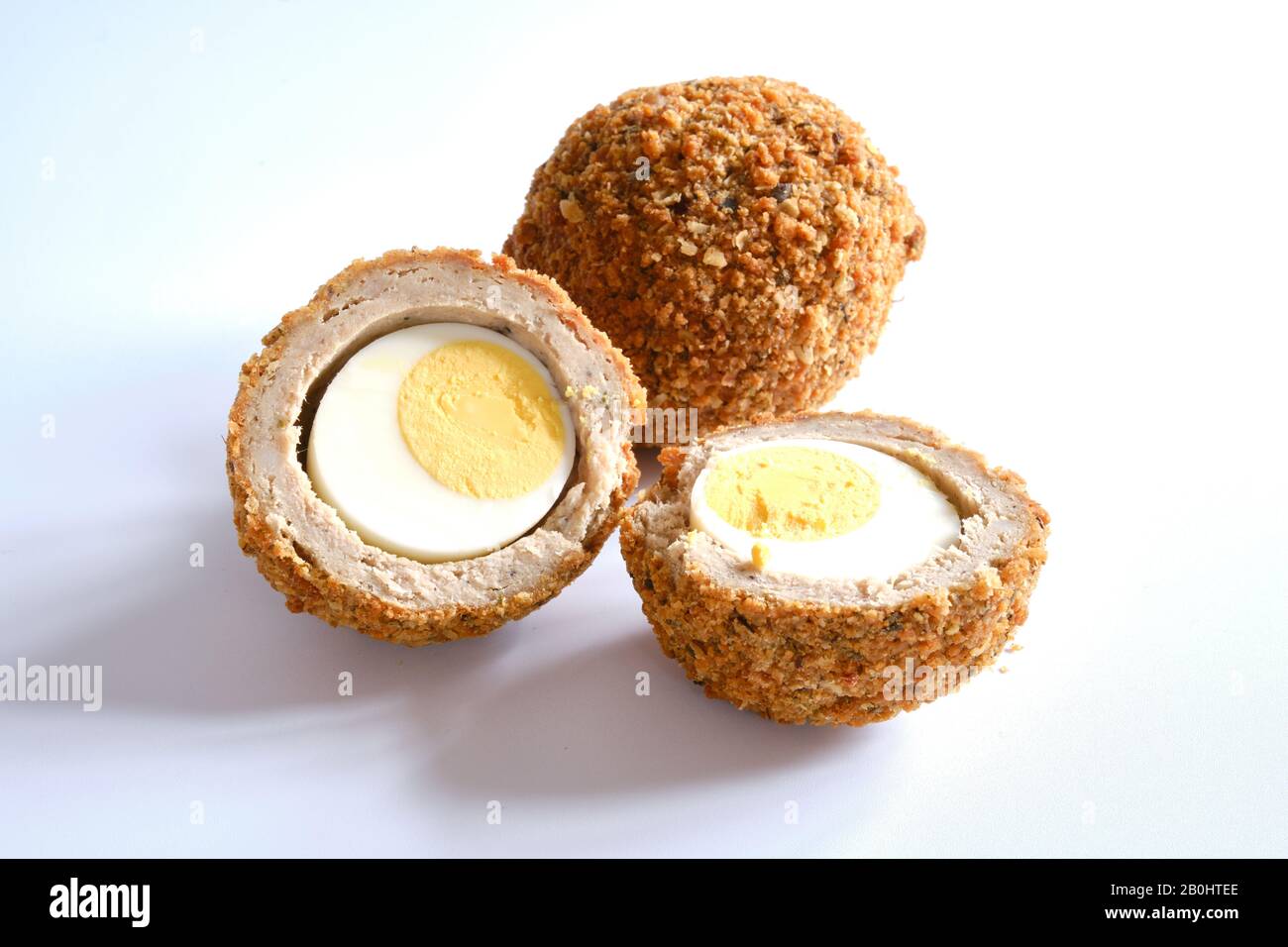 Scotch eggs a traditional savoury snack consisting of a hard boiled egg surrounded by sausage meat and bread crumbs white background Stock Photo