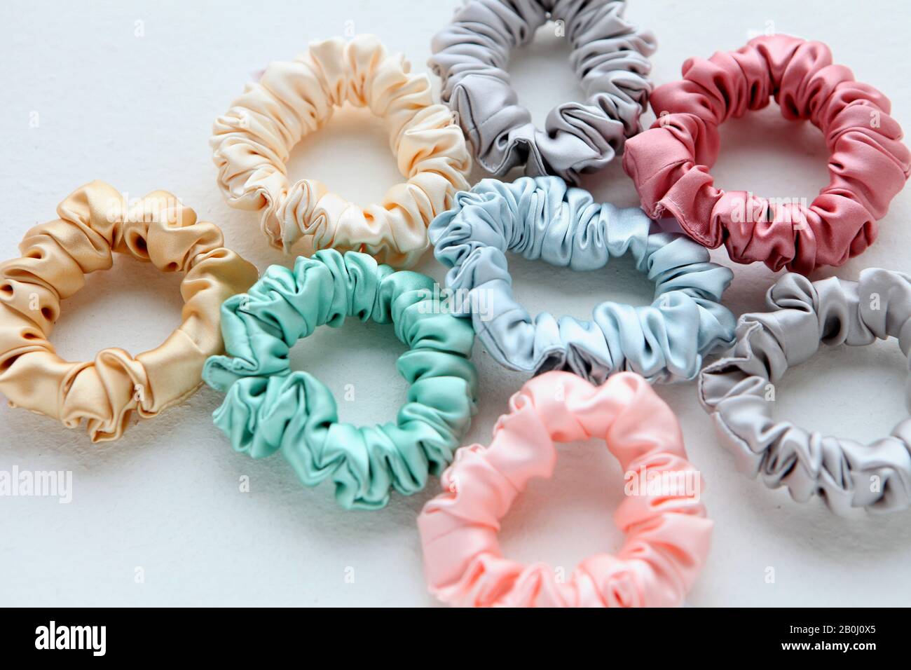 Lot of Colorful silk Scrunchies on white. Flat lay Hairdressing tools and accessories. Hair Scrunchies, Elastic HairBands, Bobble Sports Scrunchie Stock Photo