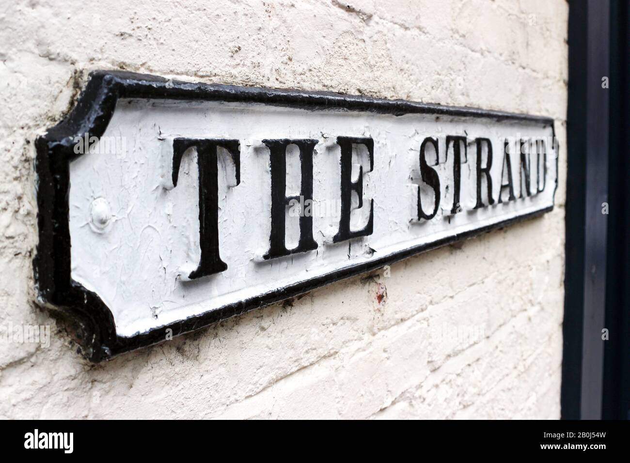 The Strand. Vintage British street sign on white brick wall in Derby