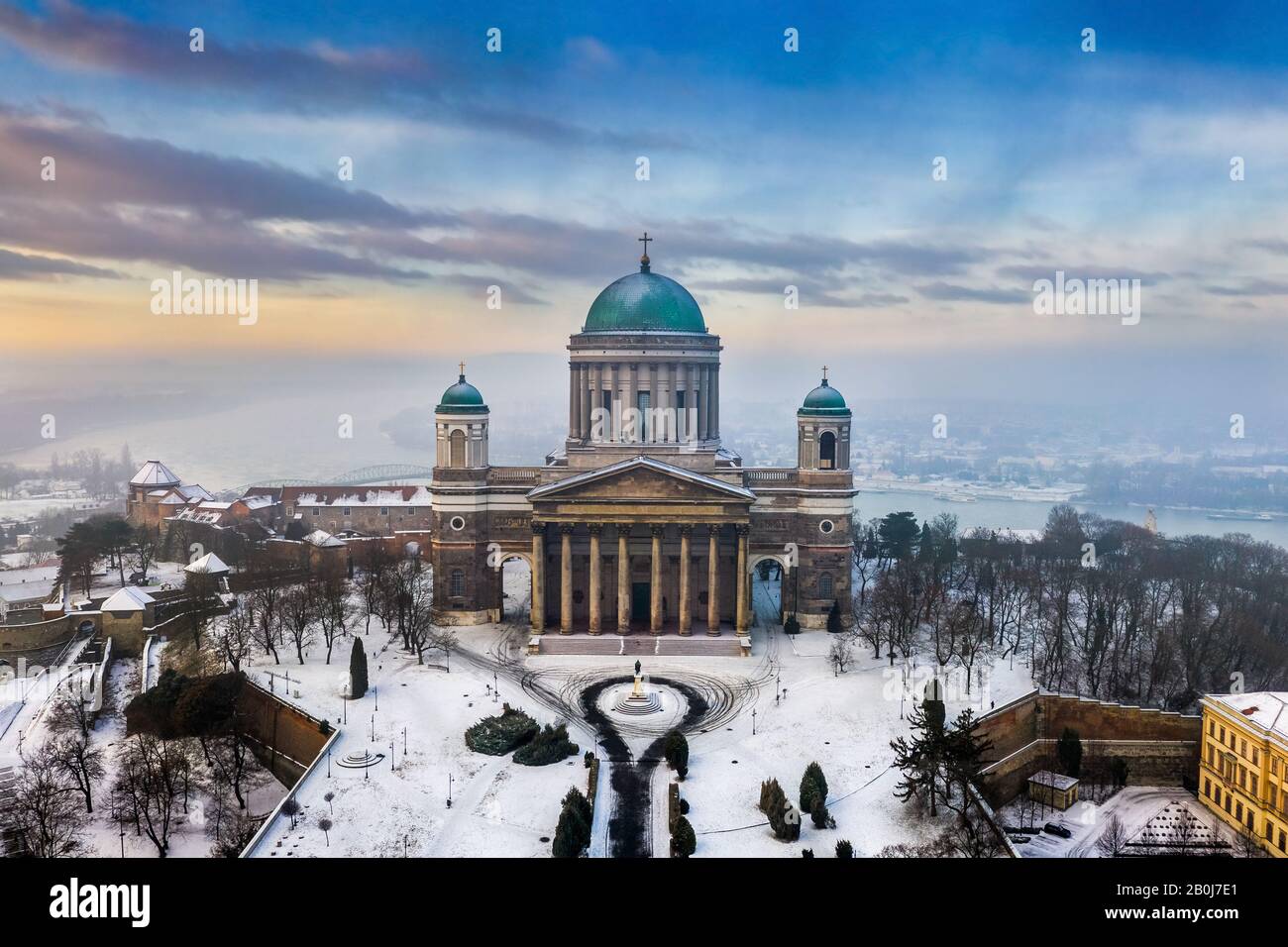 Esztergom, Hungary - Aerial view of the beautiful snowy Basilica of Esztergom with Slovakia at the background on a foggy winter morning Stock Photo