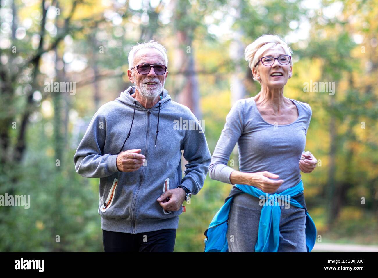 old couple of pensioners running in park Stock Photo