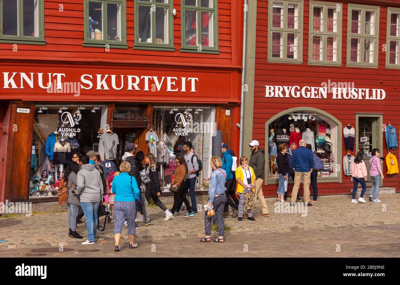 BERGEN, NORWAY - Tourists visit Bryggen, Hanseatic heritage buildings on dock in Vågen Harbour. Stock Photo