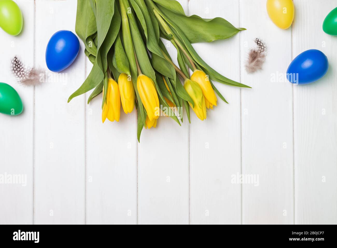 Decorative eggs and yellow tulips on white background Stock Photo - Alamy