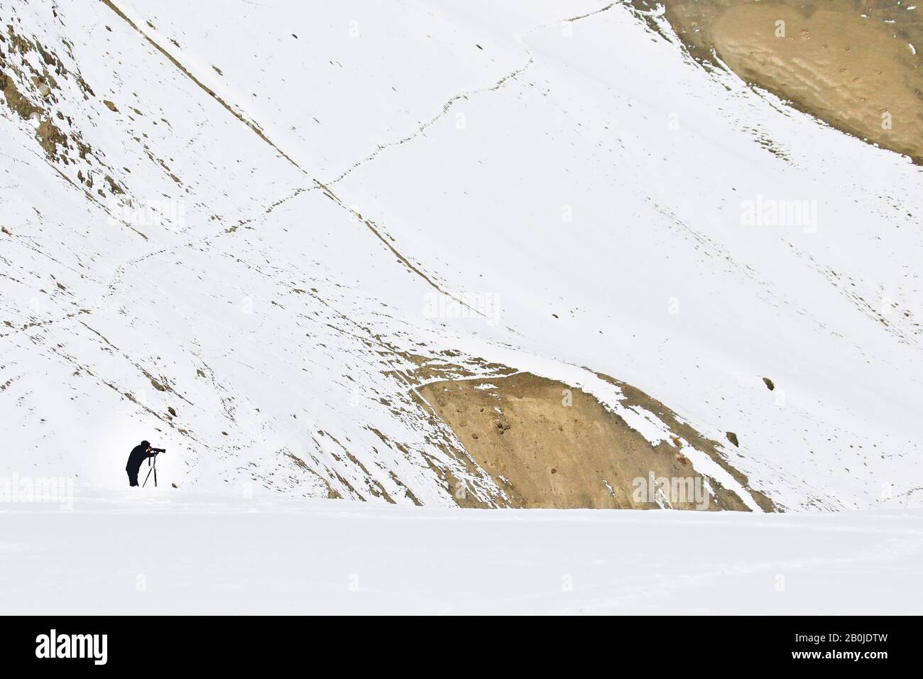 Photographer searching snow leopard in Rumbak valley. Ladakh. Himalayas. India Stock Photo