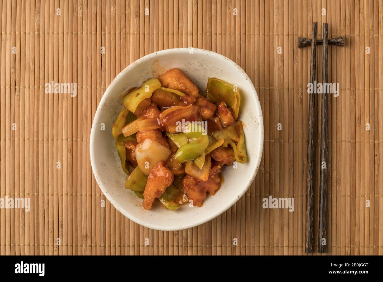 bowl of sweet and sour chicken on a table Stock Photo