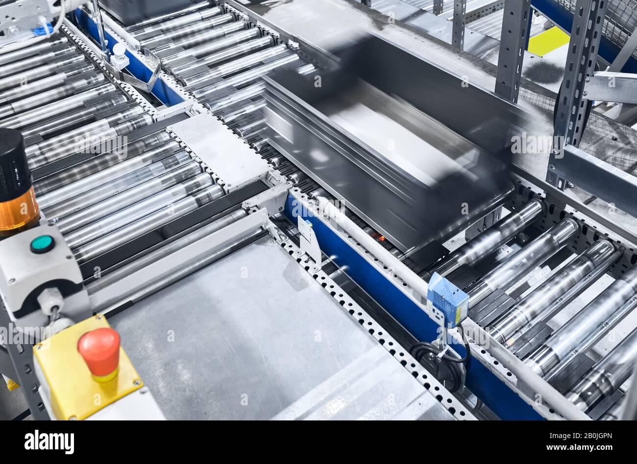 Modern conveyor system with box in motion, shallow depth of field. Stock Photo