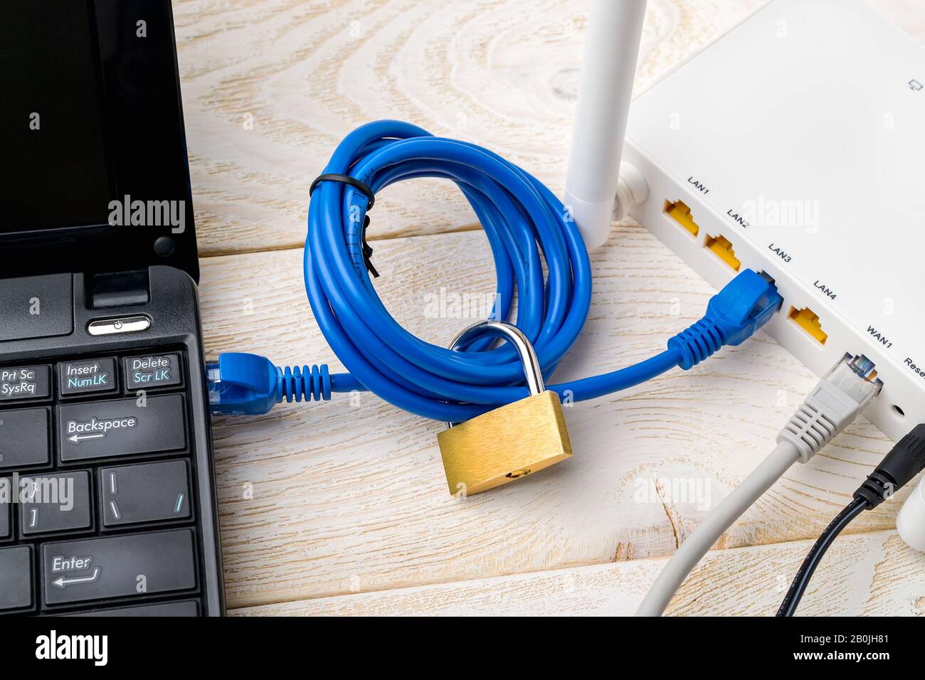 Padlock on a network cable connecting laptop and white Wi-Fi router on a  wooden table. Forbidden or limited internet and internet censorship  concepts Stock Photo - Alamy