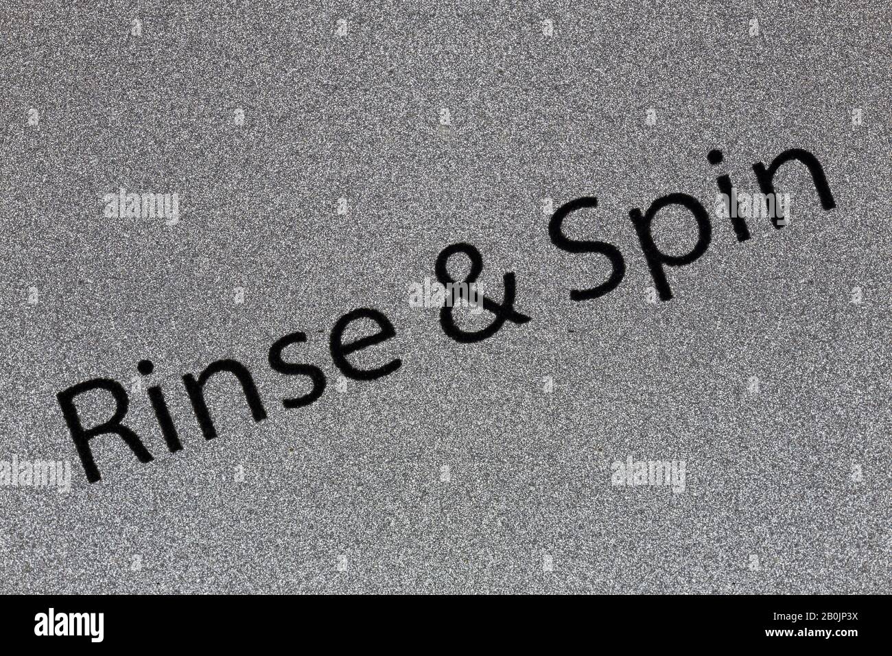 Macro close up photograph of rinse and spin setting detail on washing machine control knob.. Stock Photo