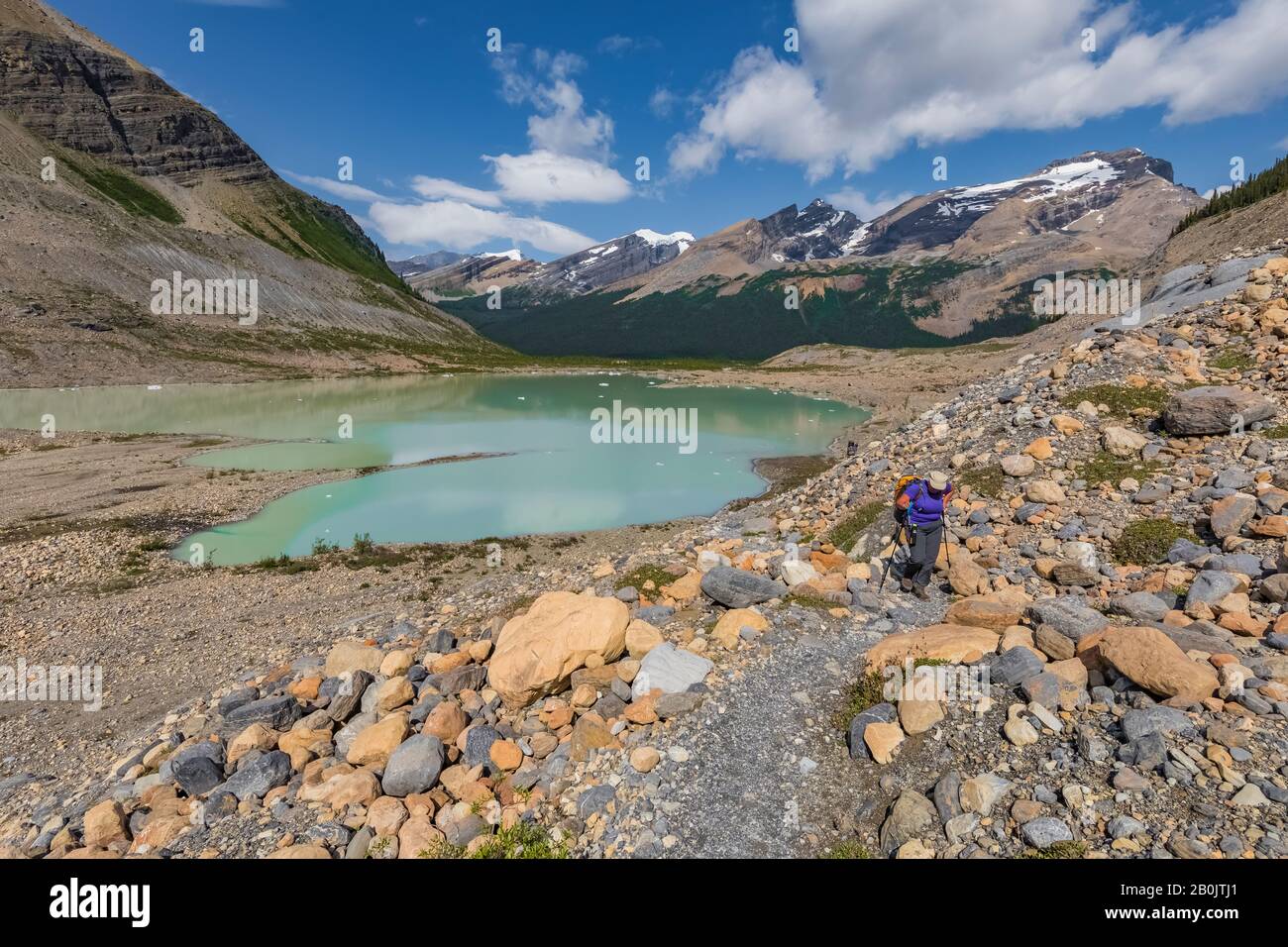 Hiker at glacial lake below Robson Glacier in in Mount Robson Provincial Park, British Columbia, Canada [No model release; available for editorial lic Stock Photo