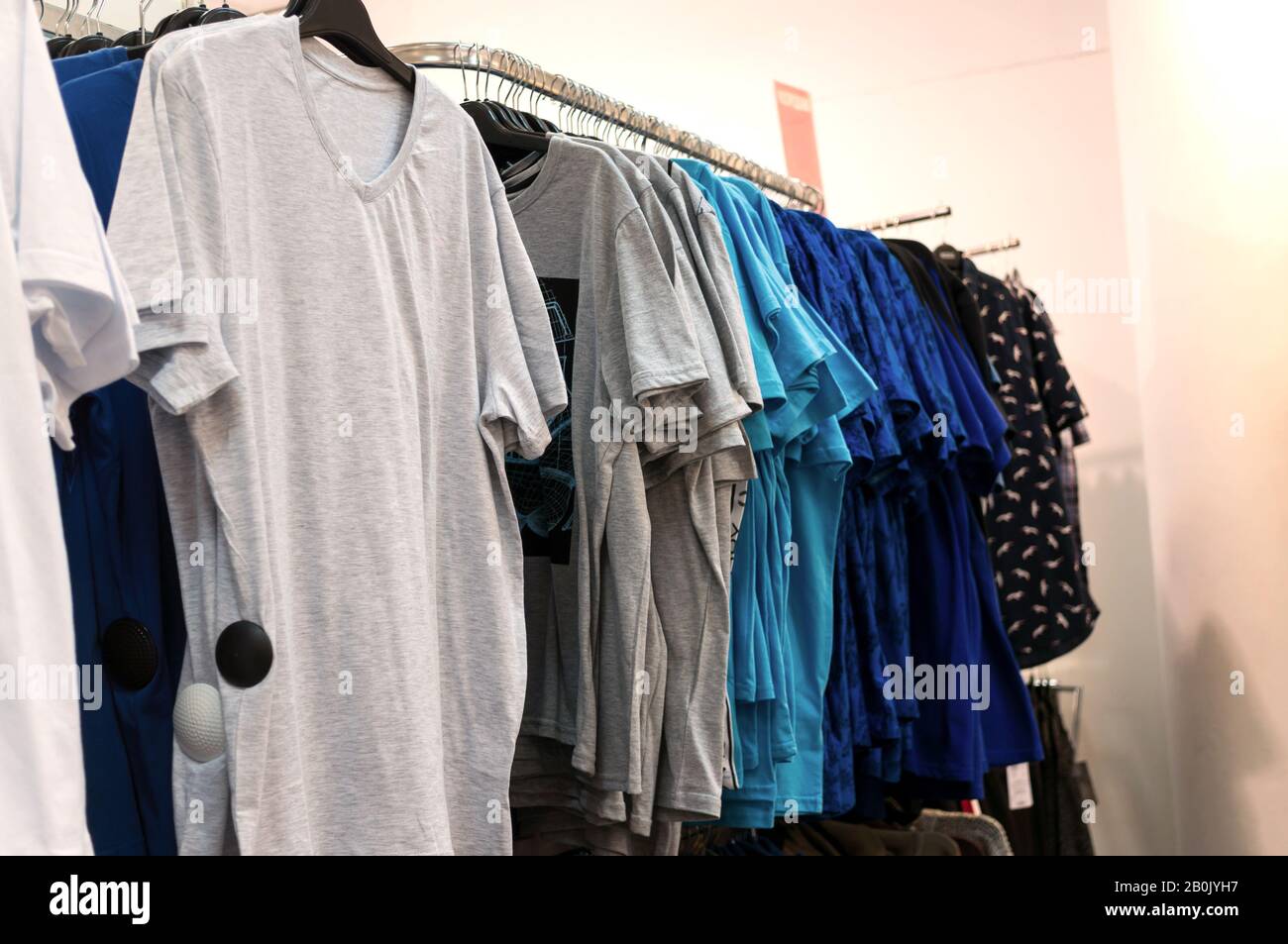 https://c8.alamy.com/comp/2B0JYH7/mens-t-shirts-on-hangers-in-a-clothing-store-2B0JYH7.jpg
