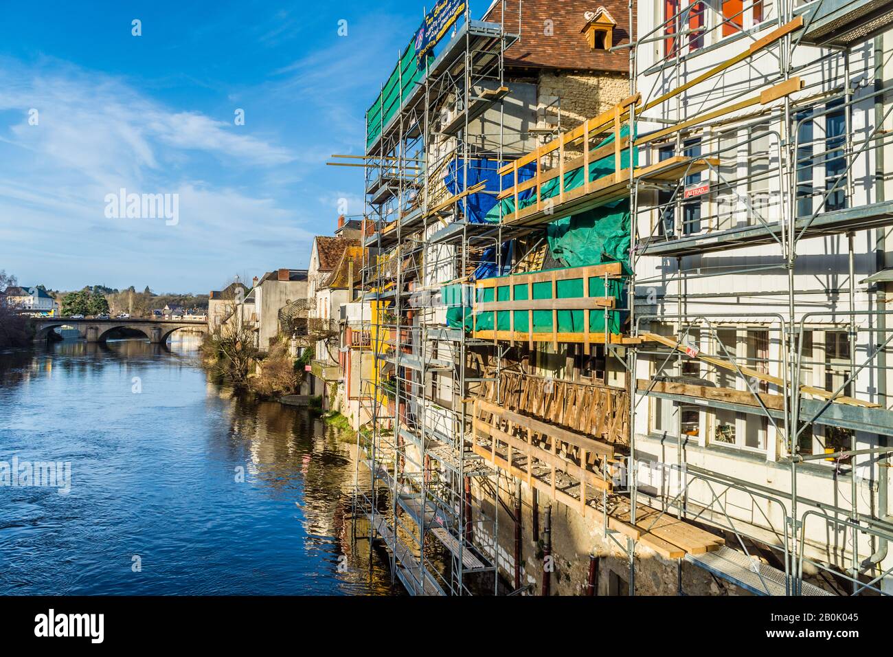 'Altrad' modular scaffolding on backs of houses being renovated above wide river - Argenton-sur-Creuse, Indre, France. Stock Photo