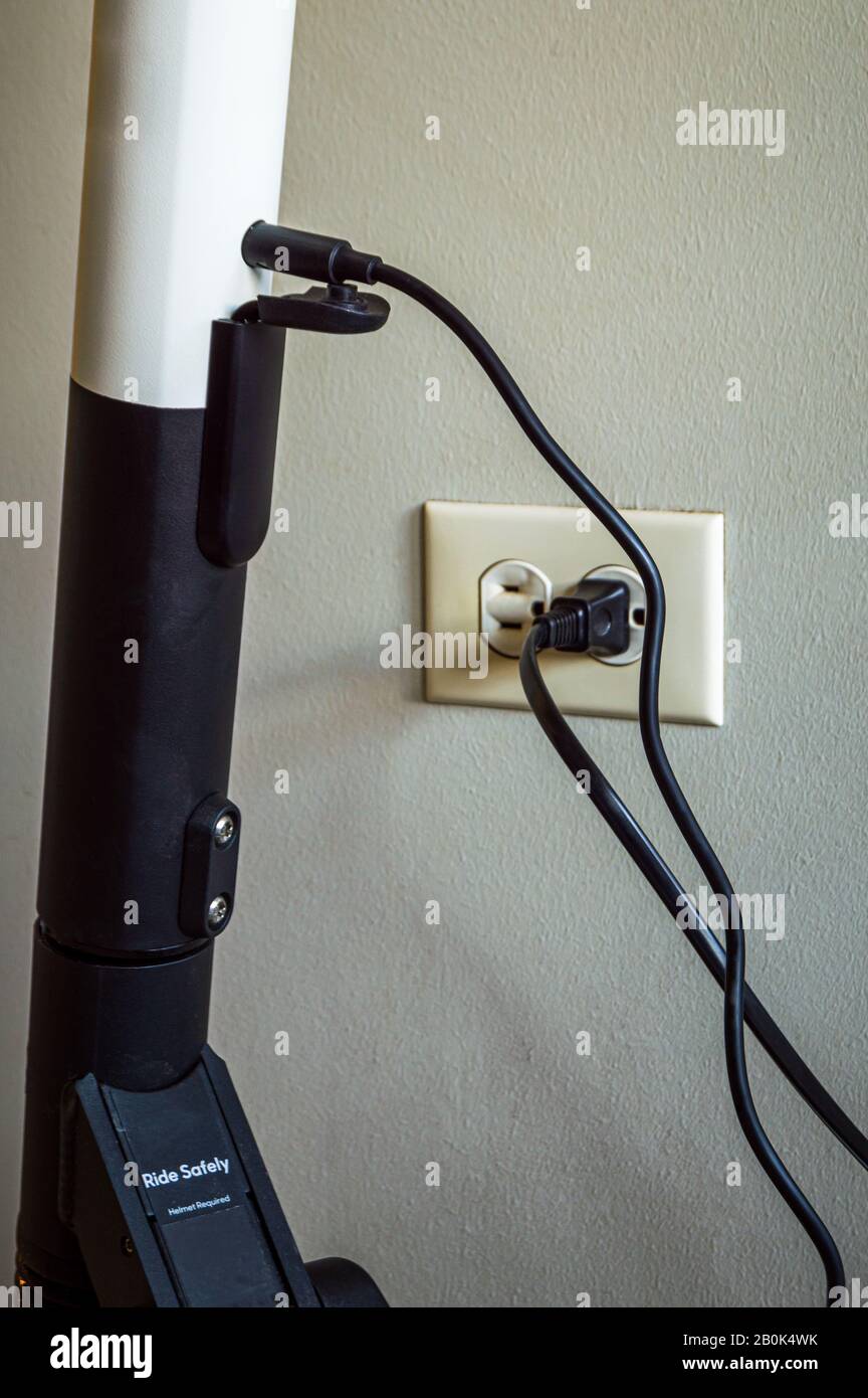 A personal electric scooter is recharging indoors Stock Photo