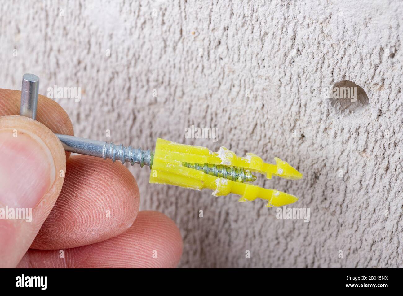 Hole in the wall, screw and dowel for fixing in concrete. Wall mounting