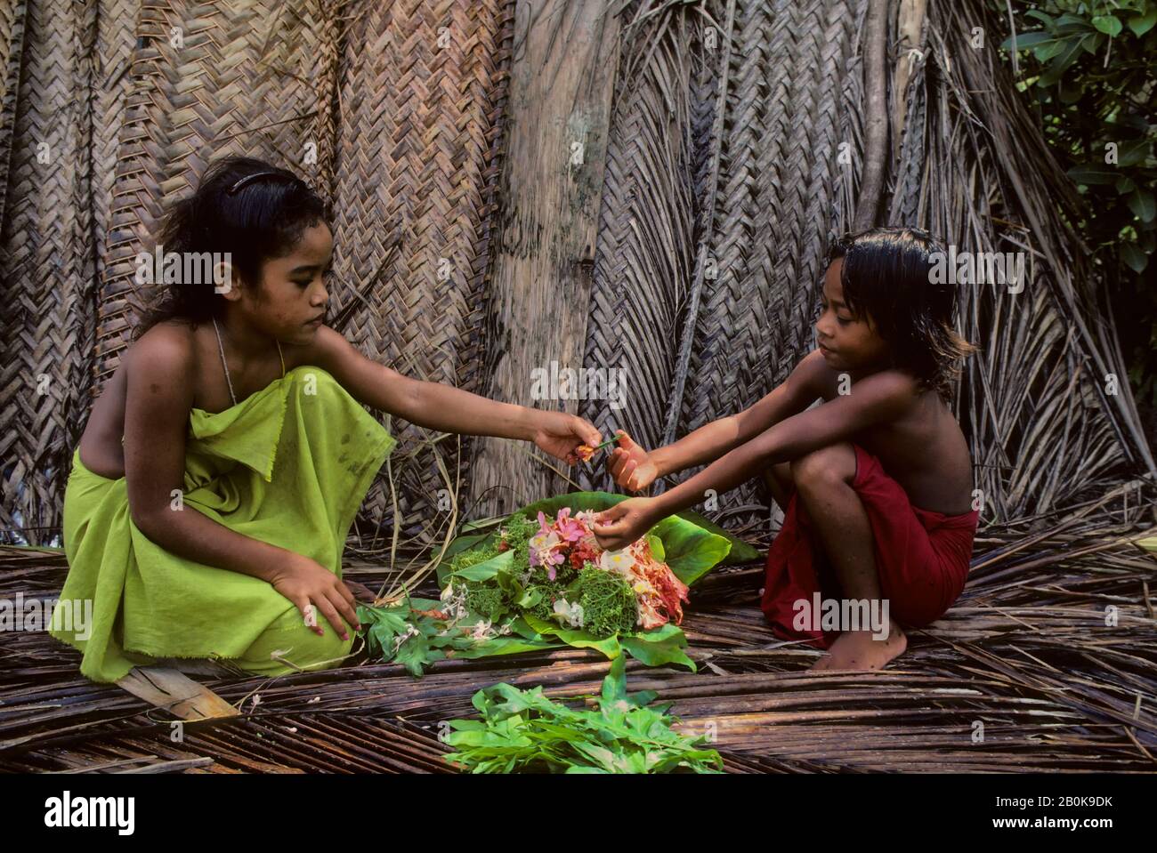 MICRONESIA, CAROLINE ISLS. PULAP ISLAND, NATIVE GIRLS MAKING FLOWER LEIS Stock Photo