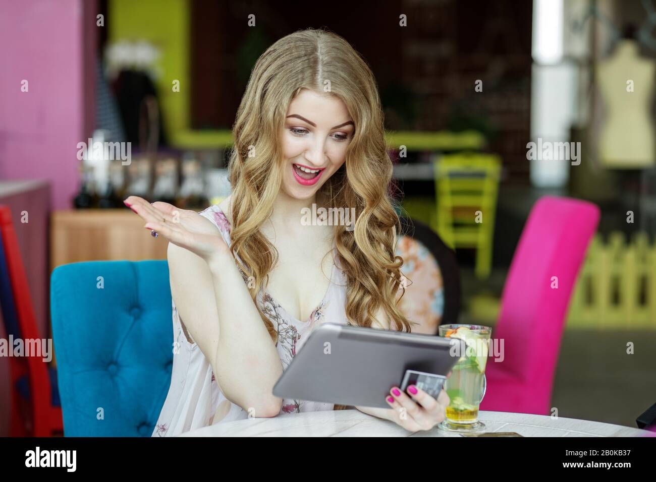 Adult smiling woman is shopping on the Internet. Big discounts. Concept of e-commerce, online shopping, internet, technology and lifestyle. Stock Photo