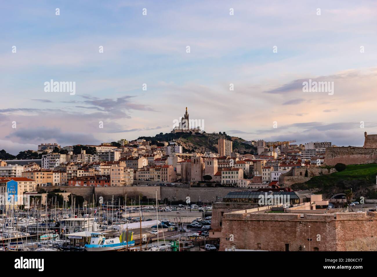 Marseille, France - January 25, 2020: the view of the Basilica Notre-Dame de la Garde and the old port at sunset Stock Photo