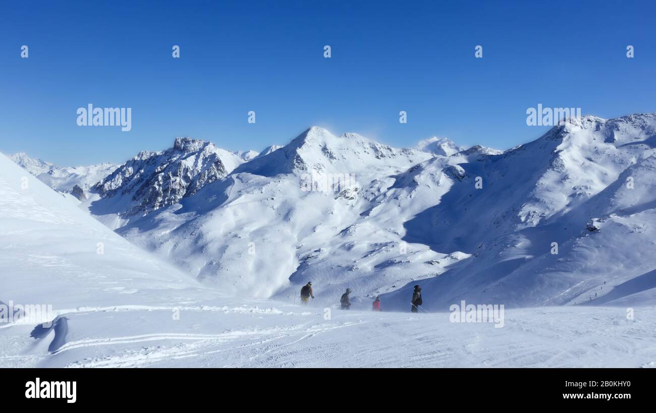 Skiers on top of a snowy slope on a windy day, in the skiing resort of 3 Valleys, Val Thorens , Alps, France . Stock Photo