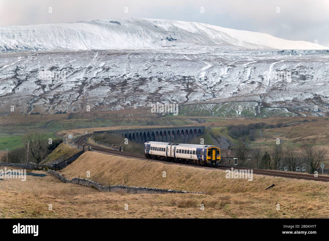 A  Northern Rail Sprinter passenger train crosses the famous Ribblehead Viaduct in the Yorkshire Dales National Park, UK. Whernside peak is behind. Stock Photo