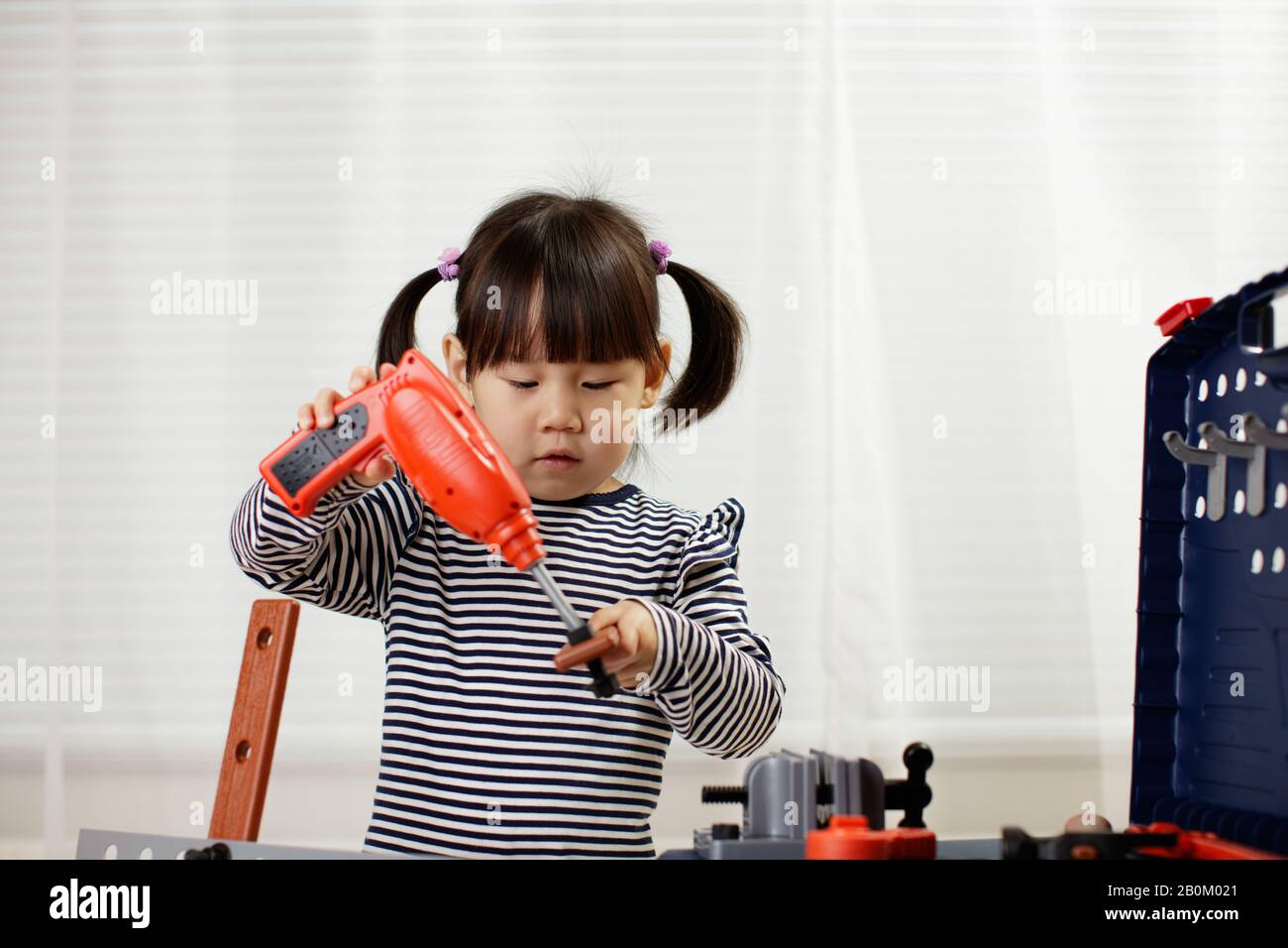 toddler girl pretend using DIY tool at home against white background ...