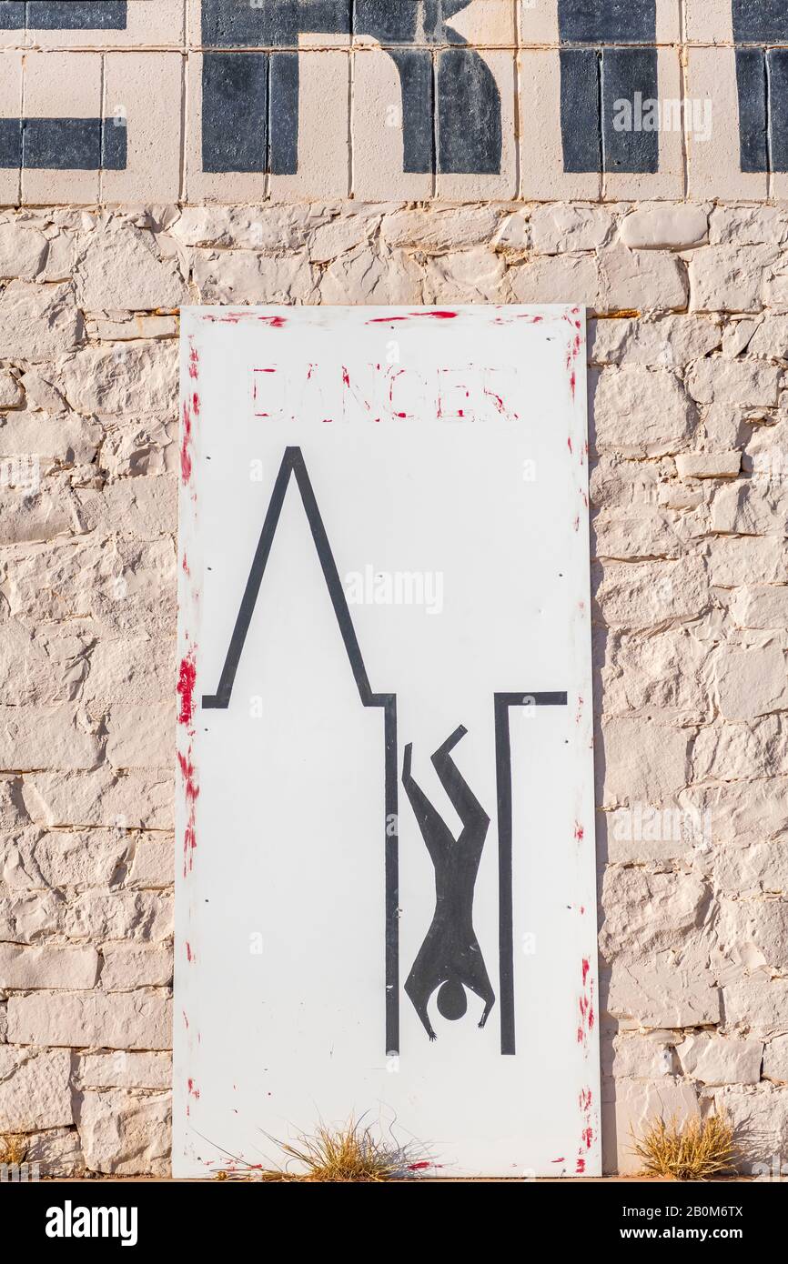 Local sign warning people to avoid falling down mine shafts in Coober Pedy, South Australia Stock Photo
