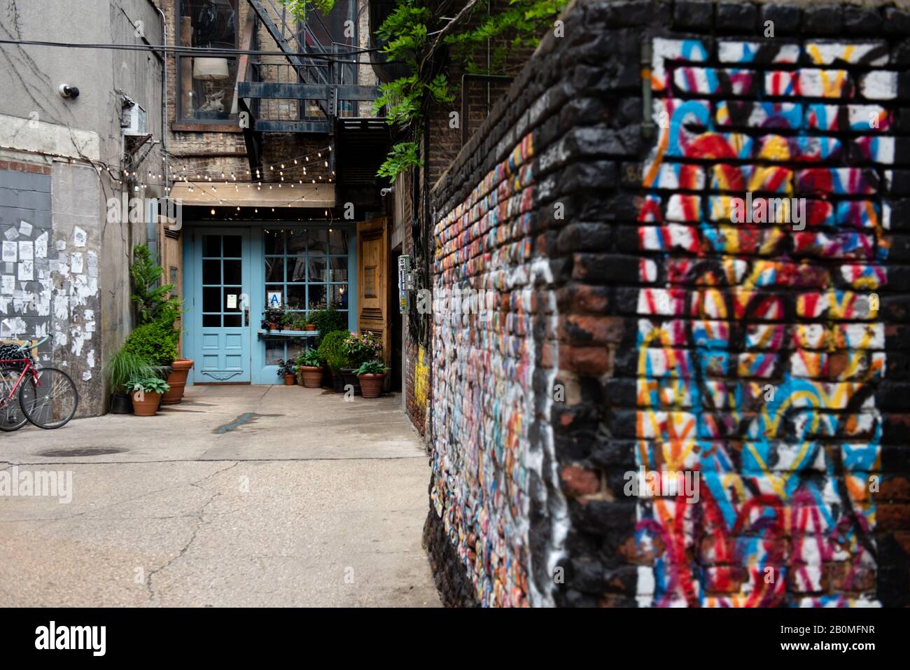 A mural of hearts are spray painted on a brick wall in an alley leading to Freemans Restaurant on the Lower East side of New York City. Stock Photo