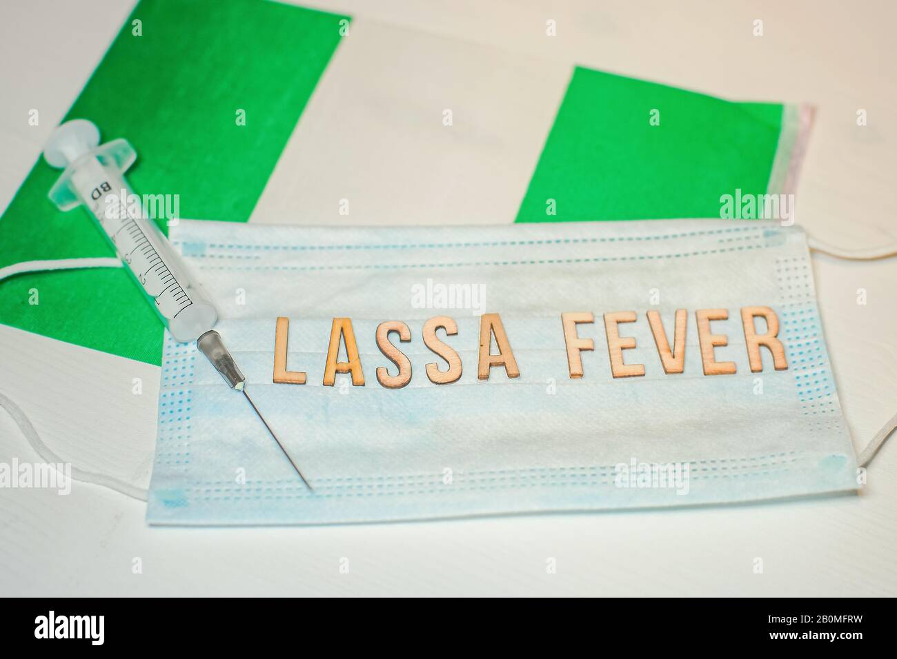 Nigerian flag under words Lassa fever outbreak concept. protective breathing mask and syringe. Lassa hemorrhagic fever LHF endemic in West Africa incl Stock Photo