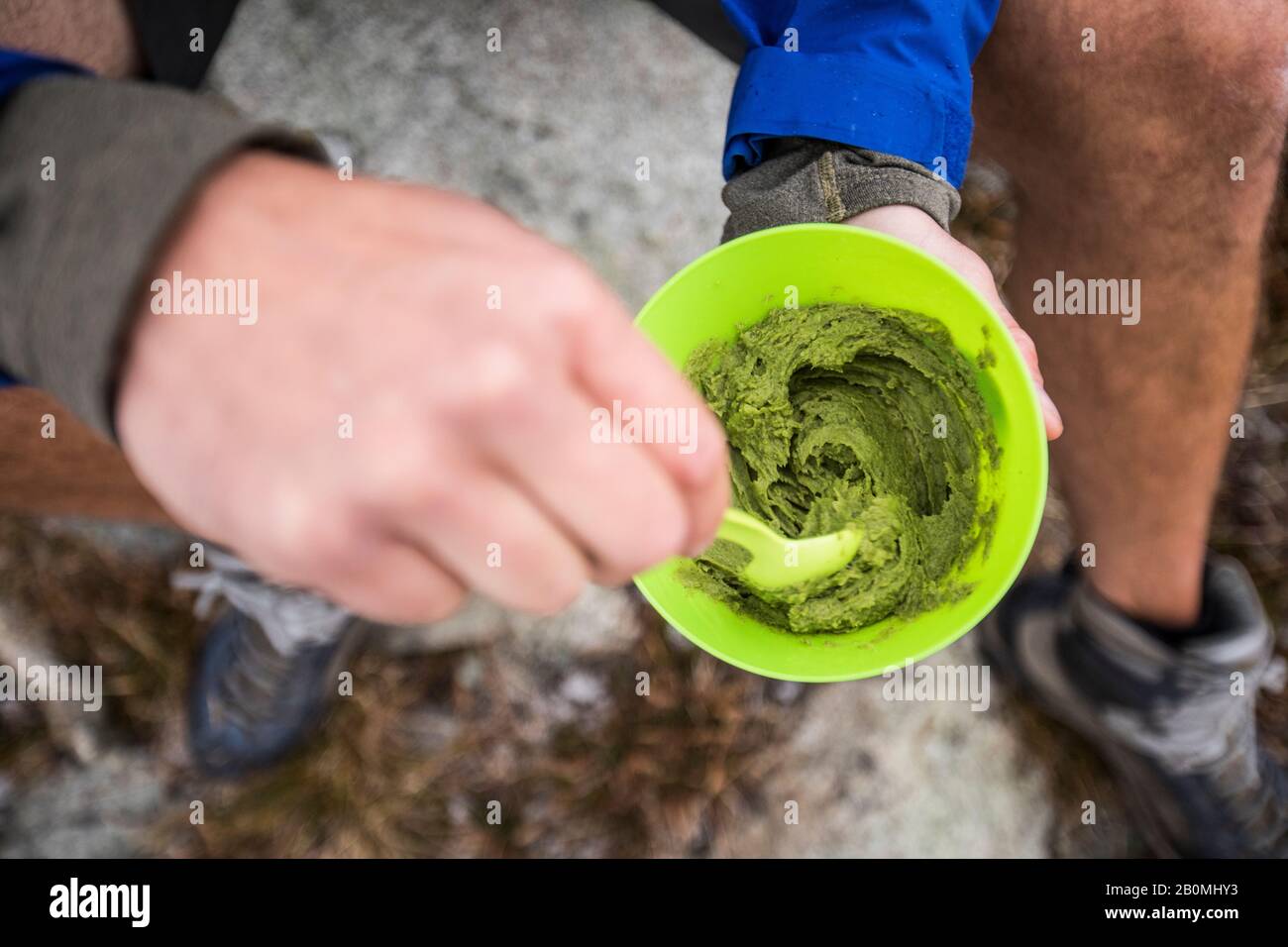 High angle view of hiker stirring bowl of guacamole. Stock Photo