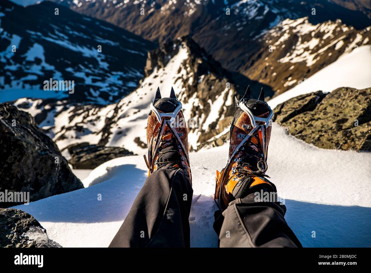 alpine mountaineering boots with crampons on top of a mountain summit Stock Photo