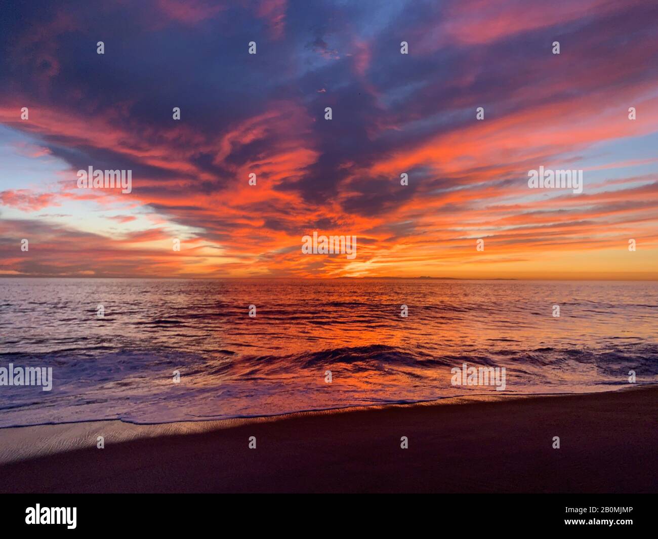 Viewers perspective of beautiful ocean sunset reflected by clouds Stock Photo