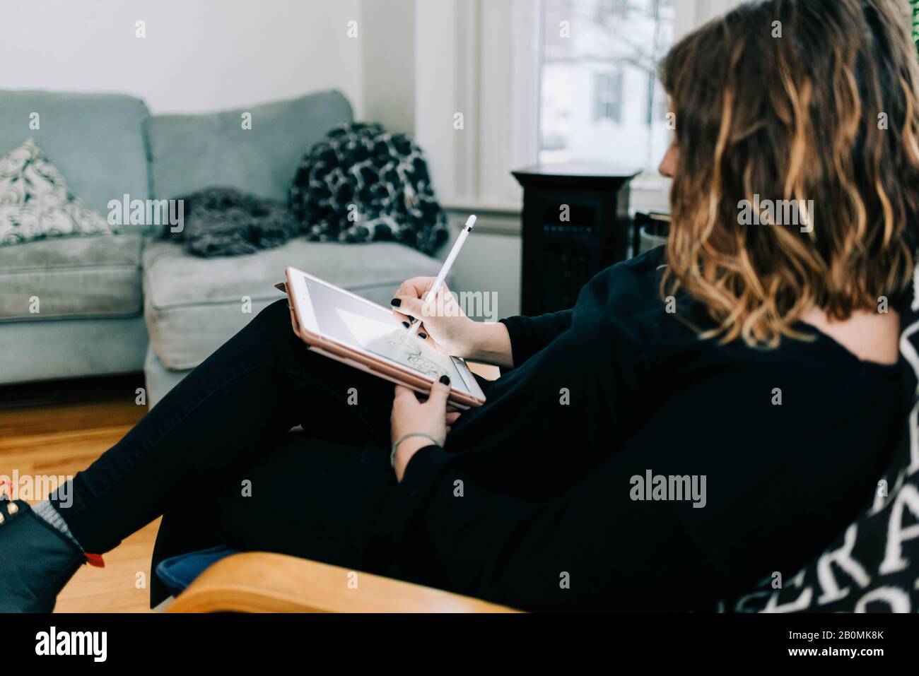 Stock photo of an artist sketching with her tablet. Stock Photo