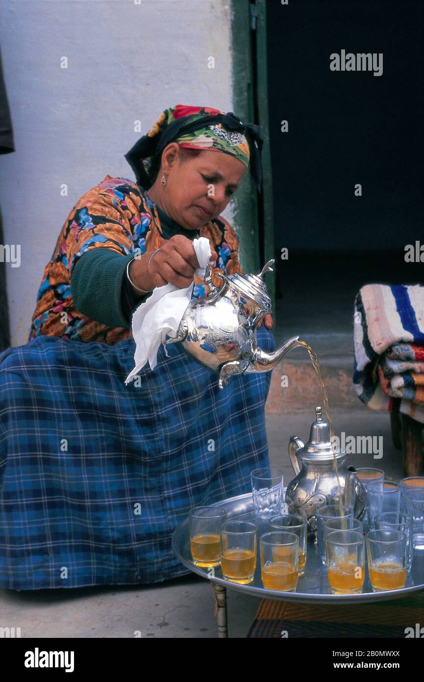 MOROCCO, NEAR MARRAKECH, ASNI VALLEY,OUIRGAN VILLAGE, BERBER WOMAN SERVING TEA, SILVER TEAPOT Stock Photo