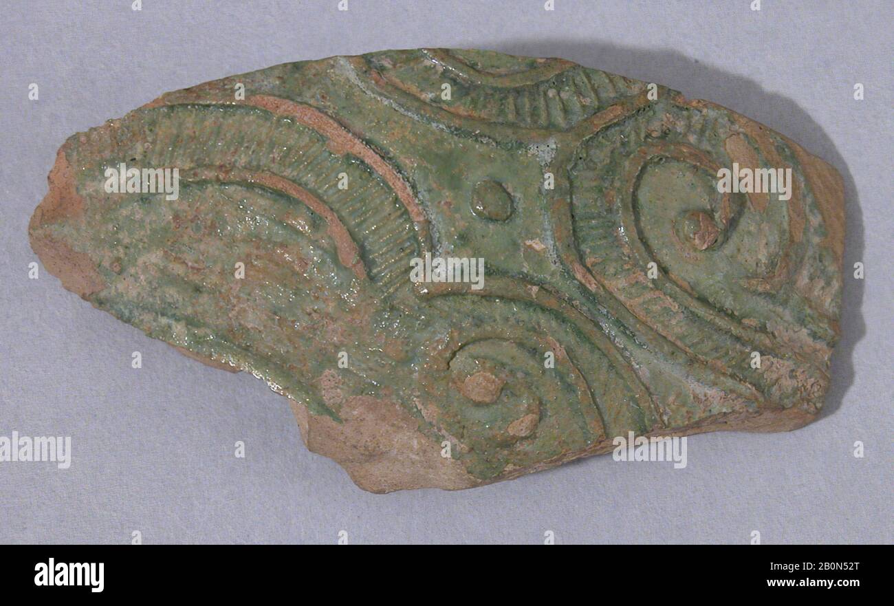 Fragment, 9th–10th century, Excavated in Iran, Nishapur, Earthenware; molded decoration of spirals and dots, green glaze, H. 1 15/16 (5 cm), W. 2 3/4 in. (7 cm), Ceramics Stock Photo